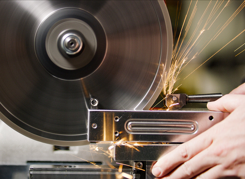 Sparks fly as an EDJY nail cutter blade is sharpened on a grinding wheel at their Ann Arbor, Michigan factory.