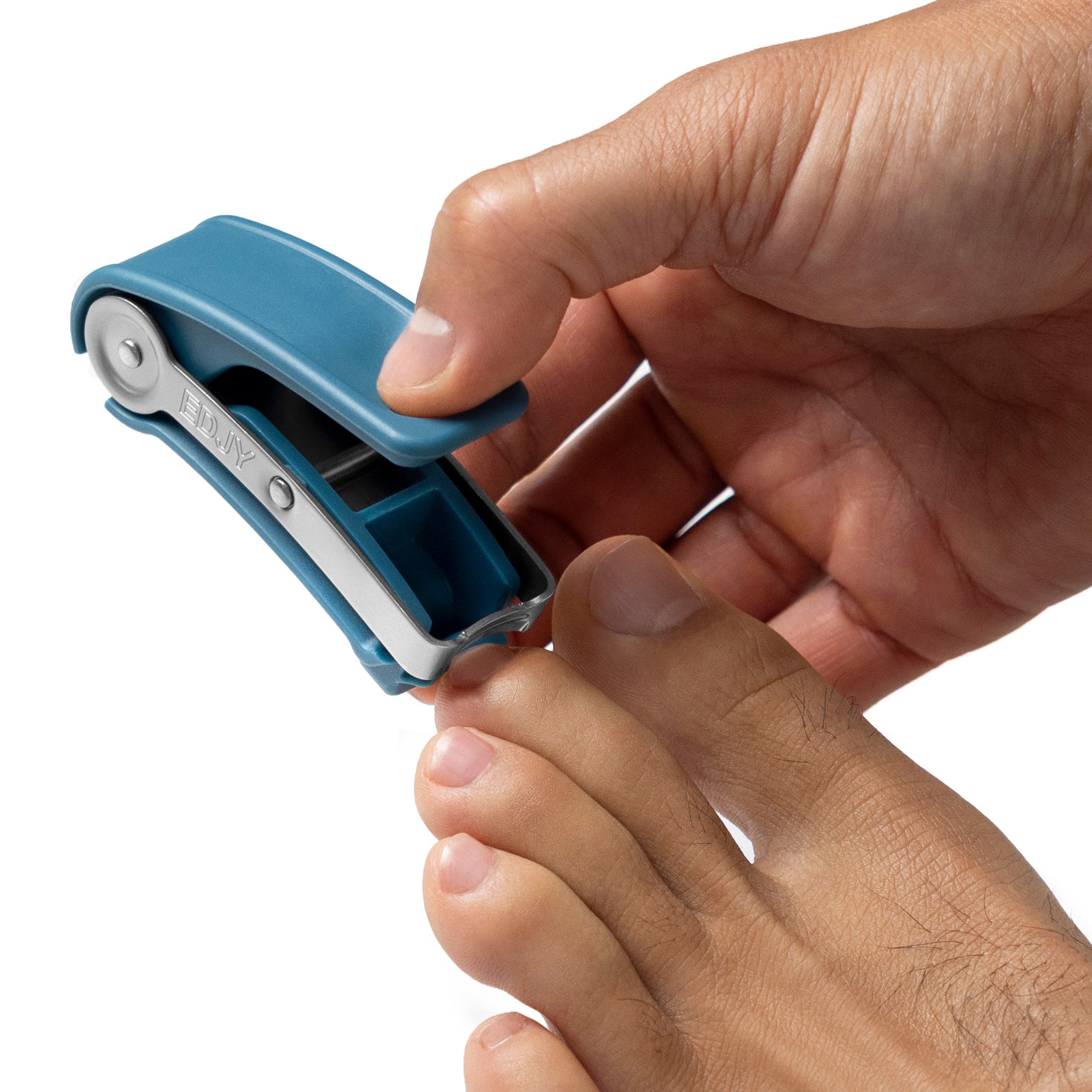 A close-up photograph of a hand using a teal EDJY toenail cutter to precisely trim a toenail.